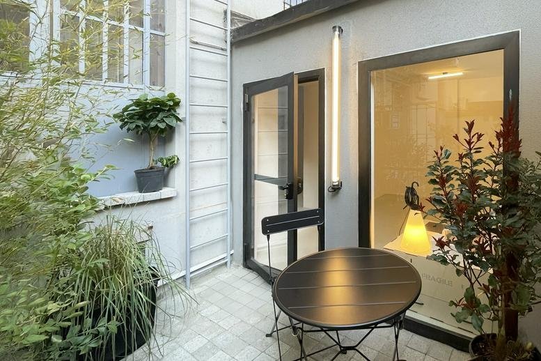 Spacious outdoor courtyard with lush greenery and patio furniture at 126, Via Nicola Antonio Porpora.
