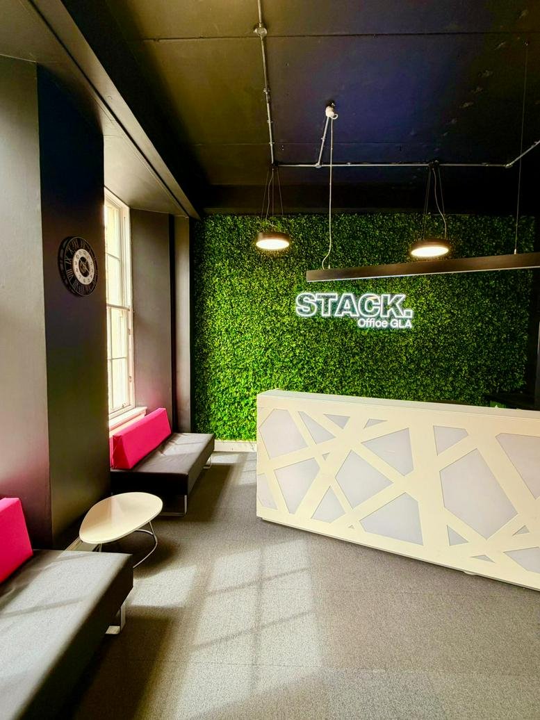 Modern reception area at 126, West Regent Street with a green moss feature wall and geometric desk.