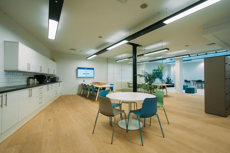 Modern communal kitchen and break area with colorful seating at 127, Portland Street.