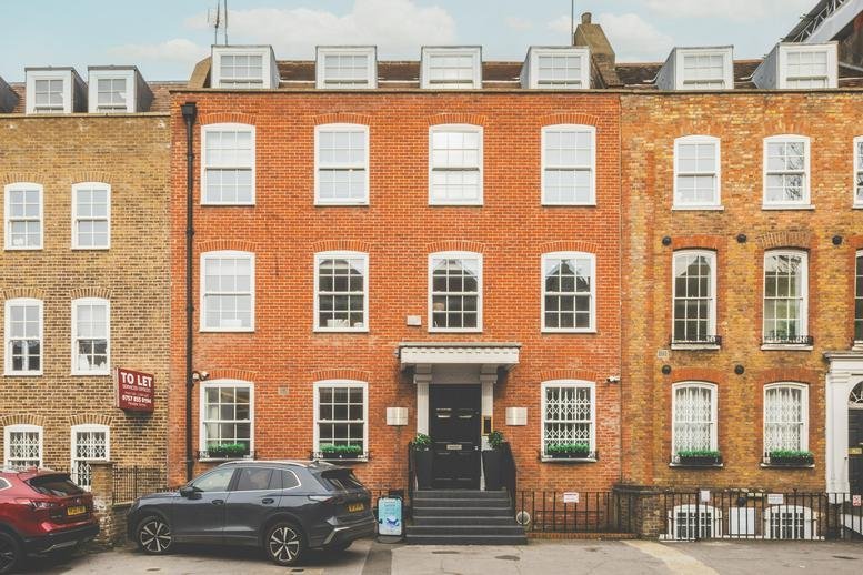Wide exterior view of the traditional red brick facade at 136-144, New Kings Road.