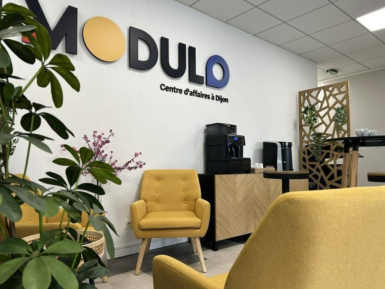 Bright reception area at 14E, Rue Pierre de Coubertin, with yellow armchairs and branded wall signage.