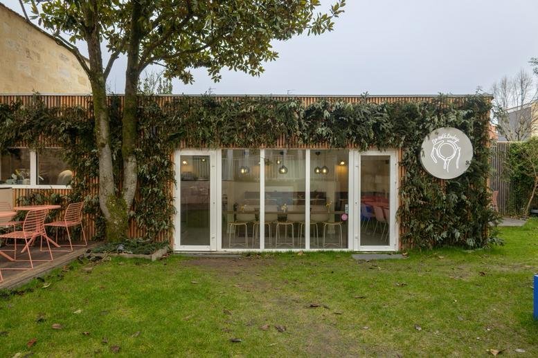 Exterior garden view of the ivy-covered brick building at 155, Rue Turenne.