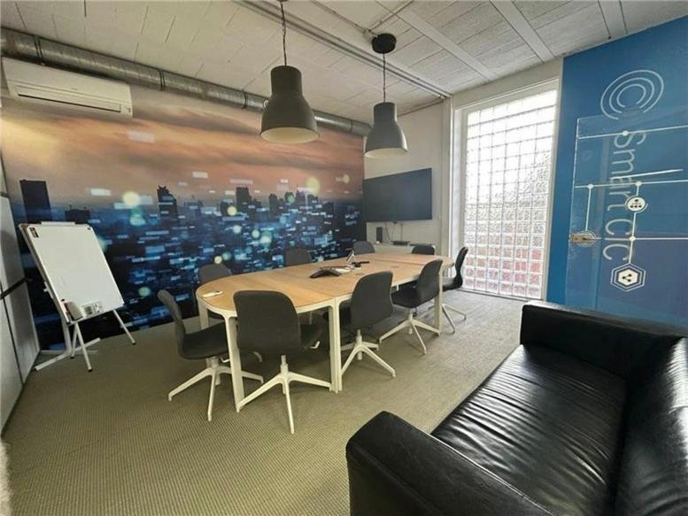 Meeting room at 16, Impasse du 11 Novembre featuring a city skyline mural and wood-toned table.