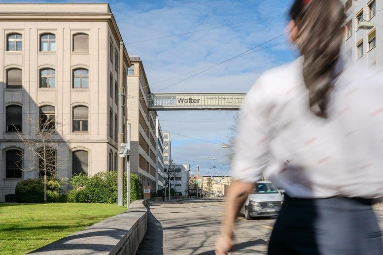 View of the 161, Klybeckstrasse industrial-style building facade with a skybridge across the street.