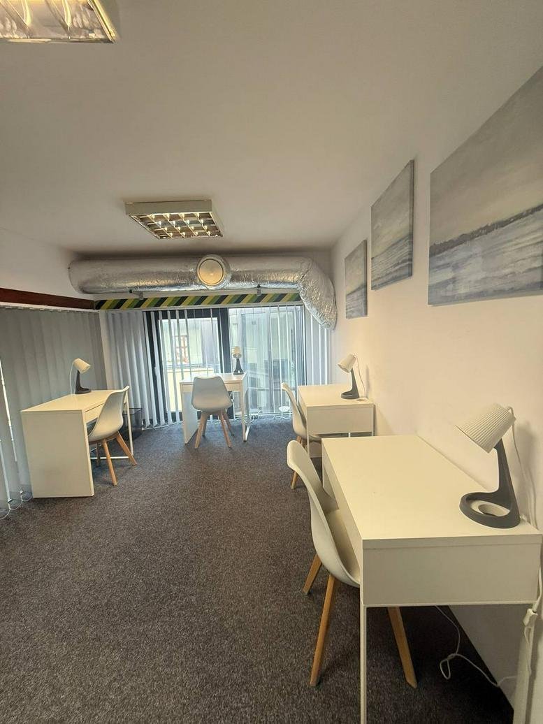 Spacious open-plan office suite with white desks and coastal wall art at 17, Ofiar Oświęcimskich.