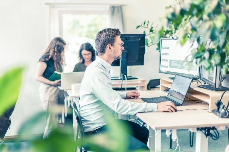 Bright open-plan office at 170, Altwiesenstrasse, with green plants and modern workstations.