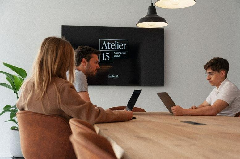 Spacious meeting room at 19, Rue Gheude, with natural light and a large screen.