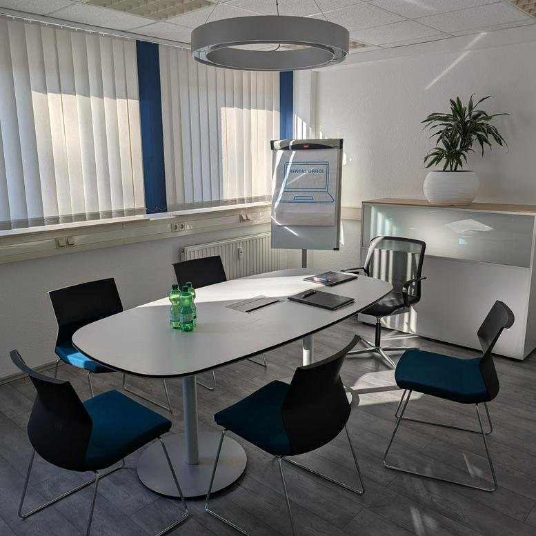 A professional meeting room at 20, Ludwig-Richter-Straße featuring a white oval table and modern blue chairs.