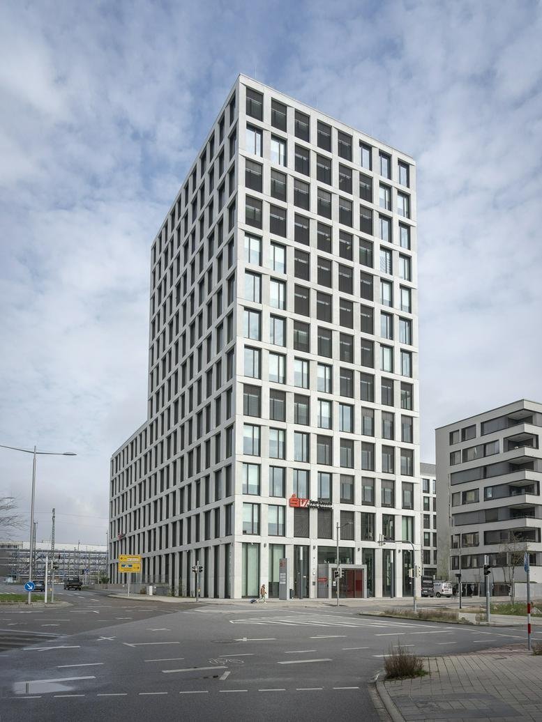 Exterior view of the modern white grid-facade office building at 25, Glücksteinallee.
