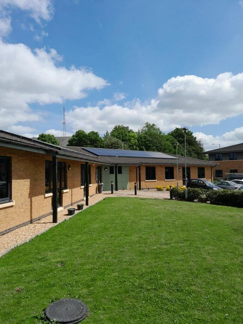 Exterior view of the brick facade and lawn at 26-28, Thorpe Wood,, with solar panels on the roof.