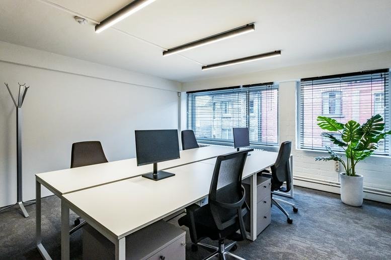 Modern office interior at 267, Hofstraat, featuring sleek white desks and large windows.