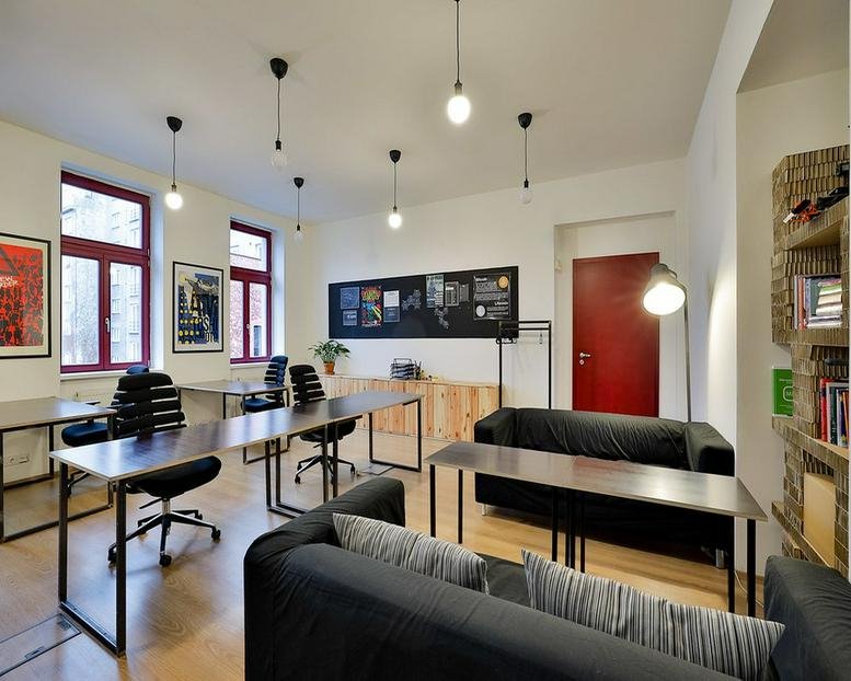Interior office space with black sofas and wooden desks at 28, Komunardů.