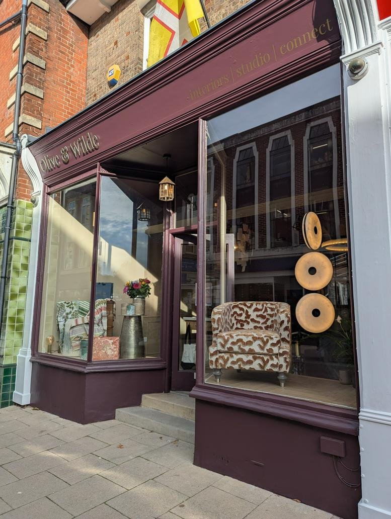 Exterior view of Olive & Wilde Studios entrance with large windows and brick details.