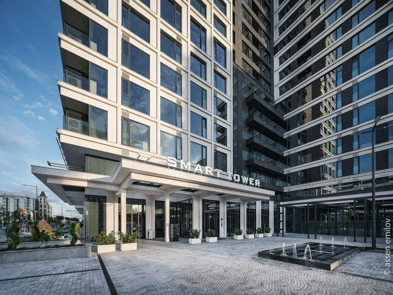 Exterior entrance of Smart Tower with a modern canopy and paved forecourt.