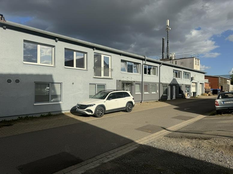 Exterior view of the 2N, Südstraße building featuring a grey facade and parking area.