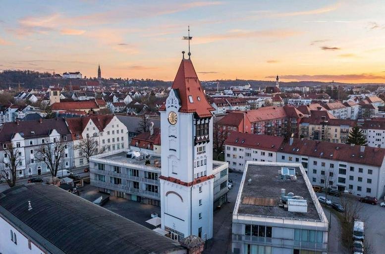 Exterior view of the clock tower building with surrounding cityscape at sunset.