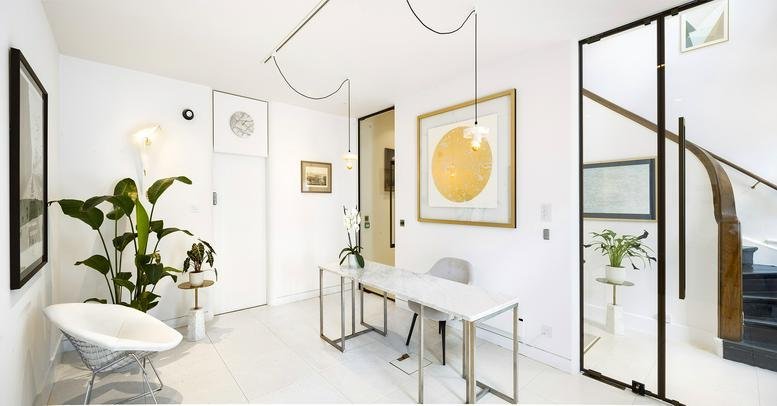 Bright, modern reception area at 338, City Road with stylish white furniture and gold accents.
