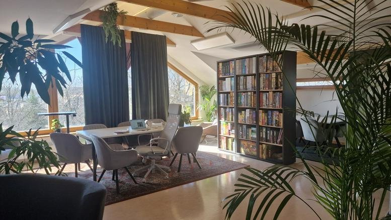 Spacious open-plan lounge and workspace at 34, Kivimurru tänav with vaulted ceilings and many plants.