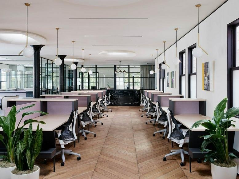 Open-plan office at 347, Old Street with herringbone wood floors, modern desks, and hanging globe lights.