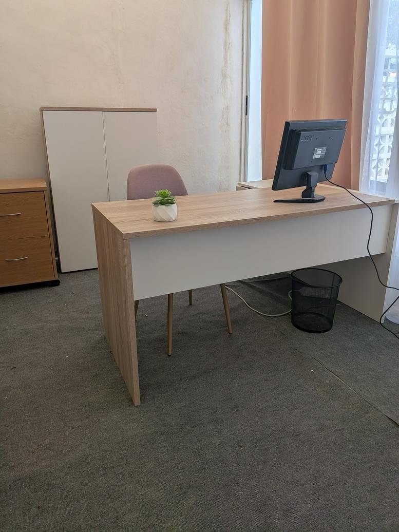 Professional workspace at 38, Avenida de las Grullas, featuring a wood-tone desk and neutral decor.