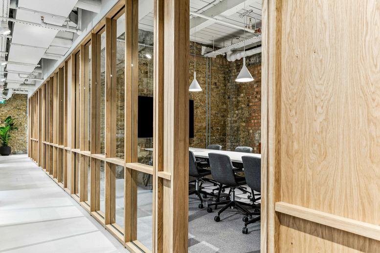 A wooden-framed glass corridor leading to a private meeting room at 4, Queen's Road.