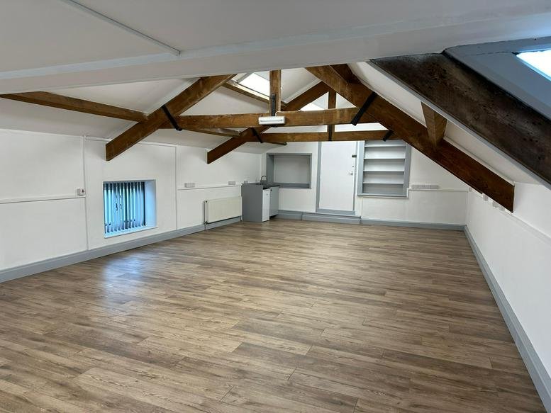 Spacious attic office at 44, Market Square, featuring exposed timber beams and light wood flooring.