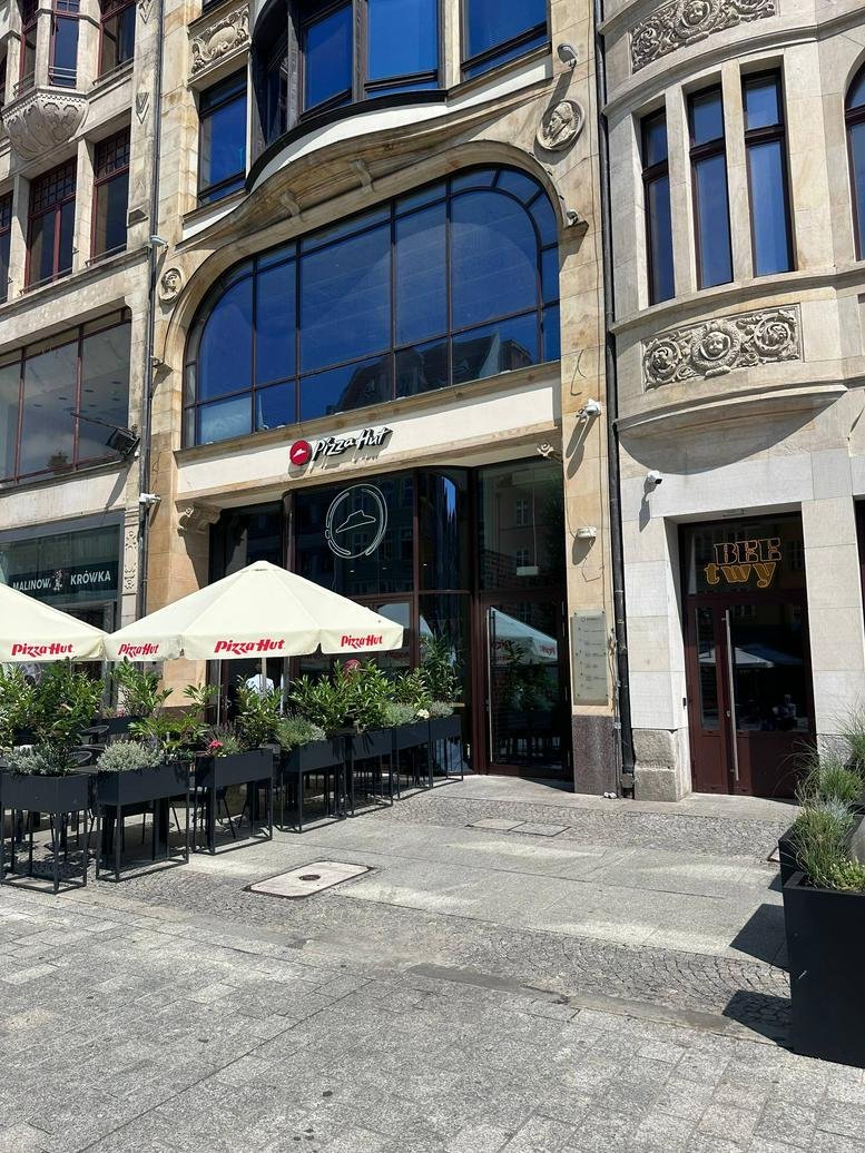 Exterior view of the historic building at 49, Rynek with a ground-floor restaurant entrance.