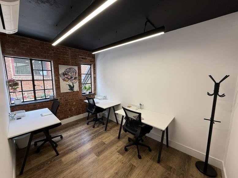 Spacious three-person office suite at 5, Crown Passage with exposed brick walls and industrial lighting.