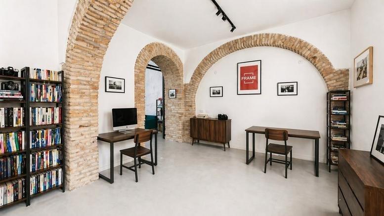 Spacious interior at 5, Via del Gazometro, with exposed brick arches and wooden desks.