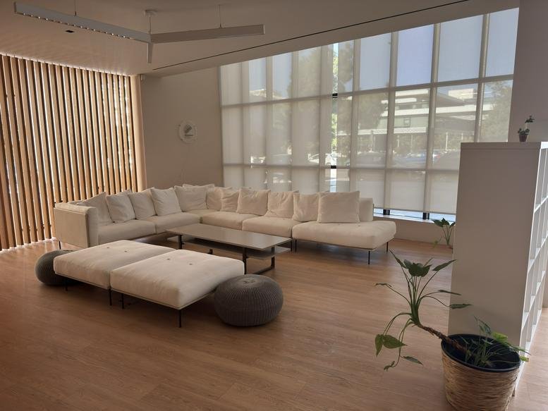 Comfortable lounge area with white sectional sofa and floor-to-ceiling windows.