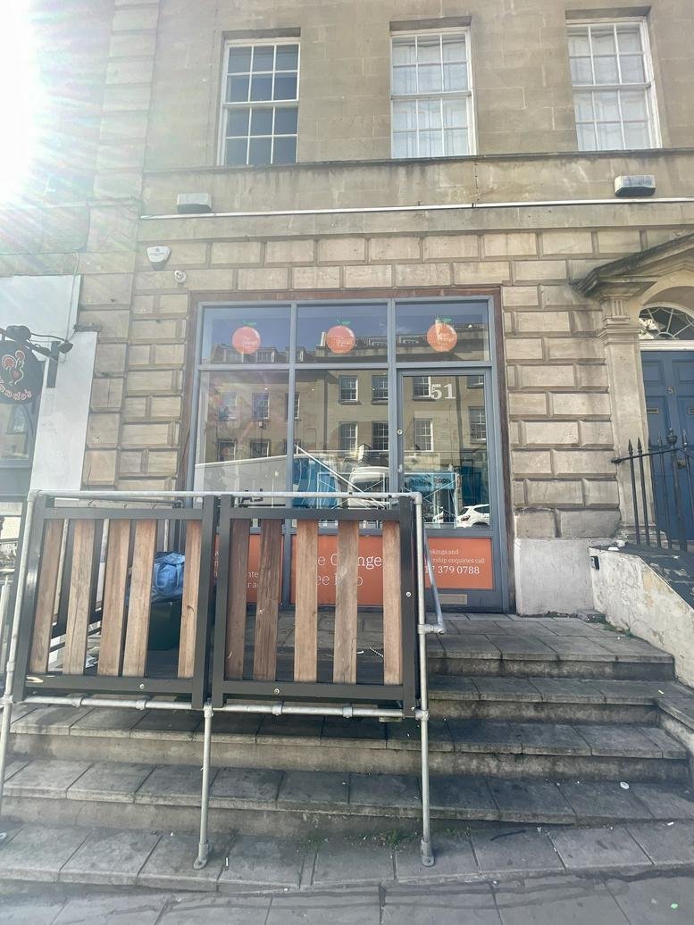 Ground floor stone facade and entrance of 51, Park Street with large front windows.