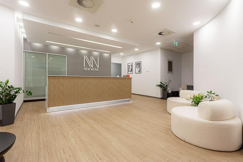 Spacious wood-paneled reception area at 51, Prosta with white lounge seating and the NN logo.