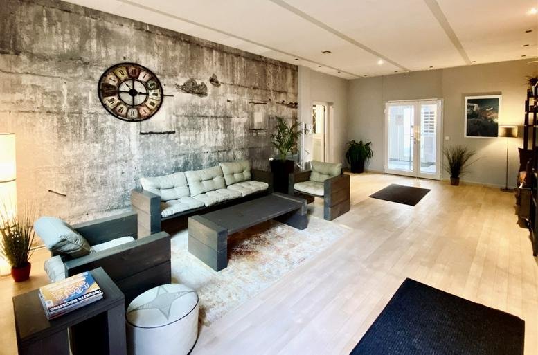 Spacious communal lounge at 53, Hans-Henny-Jahnn-Weg with industrial feature wall and comfortable seating.