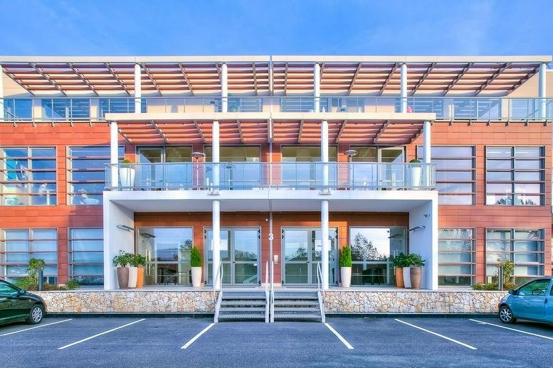 Exterior view of the modern brick and glass building at 535, Route des Lucioles.