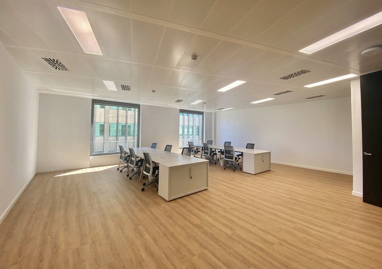 Spacious open-plan office with white desks and ergonomic chairs at 545, Avinguda Diagonal.