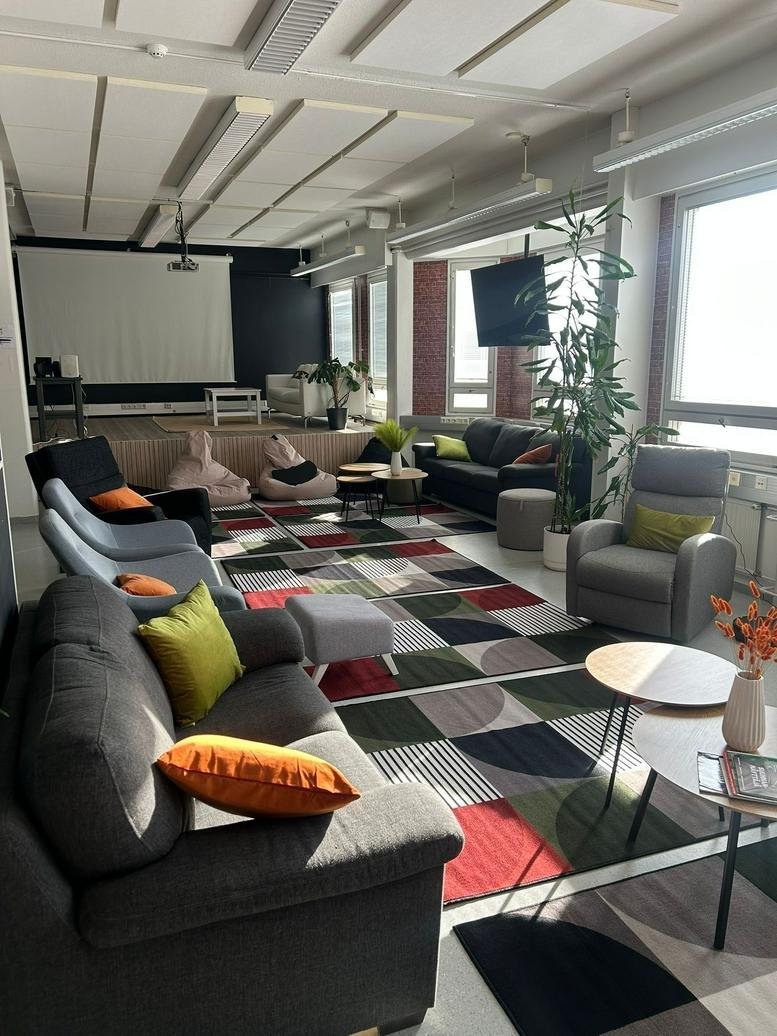 Spacious communal lounge at 56, Isokatu,, with a projector screen, colorful rugs, and comfortable seating.