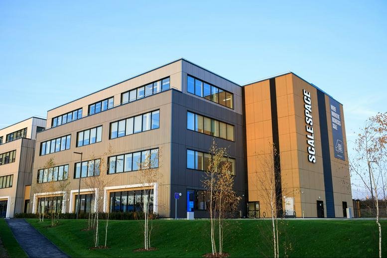 Exterior view of the modern office building at 58, Wood Lane with large glass windows and green lawns.