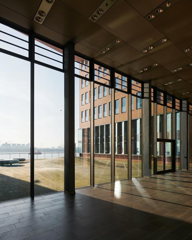 Spacious modern lobby of the building at 59, Große Elbstraße with large glass walls and waterfront views.