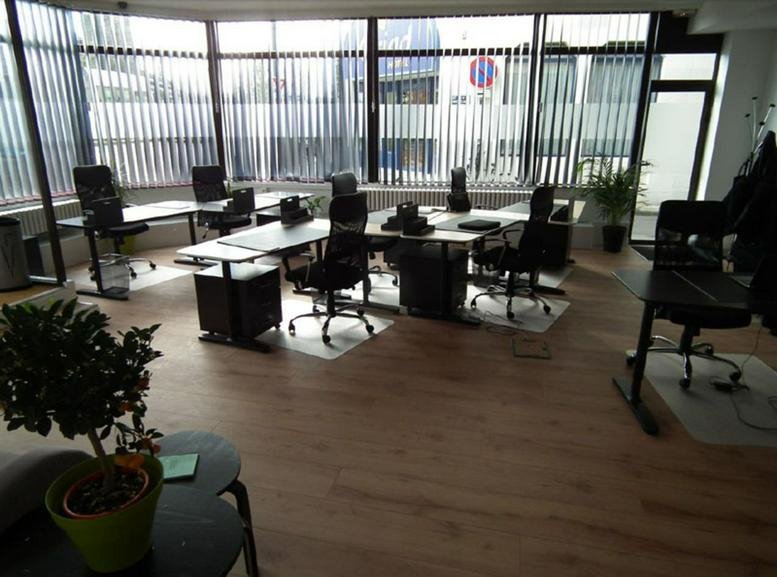 Spacious open-plan workspace at 6 Allée du commandant Charcot with wooden floors and vertical blinds.