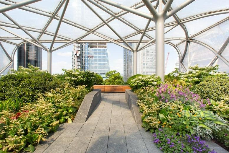 Lush rooftop garden at 6 Bevis Marks, Central London, EC3A under a geometric glass canopy.