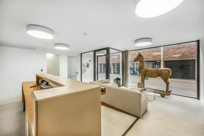 Modern reception area featuring a large wooden horse sculpture and bright circular ceiling lights.