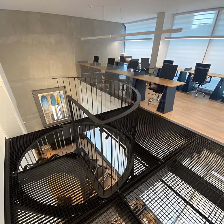 Spacious open-plan workspace at 60, Rua da Fitela featuring a spiral staircase and mezzanine desks.