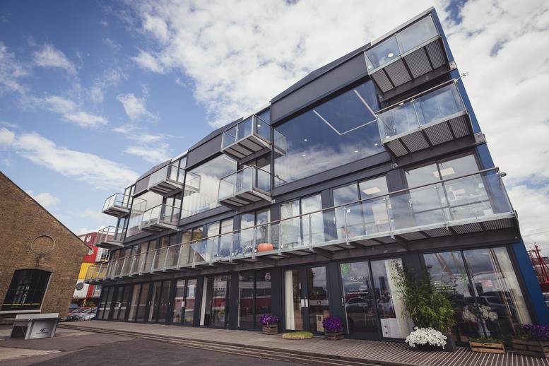 Exterior view of the modern glass-fronted office building at 64, Orchard Place, Trinity Buoy Wharf.