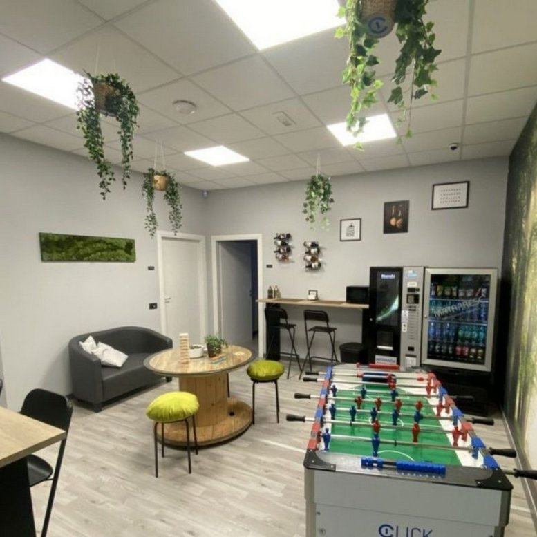 Vibrant breakout area featuring a foosball table, vending machines, and hanging plants.