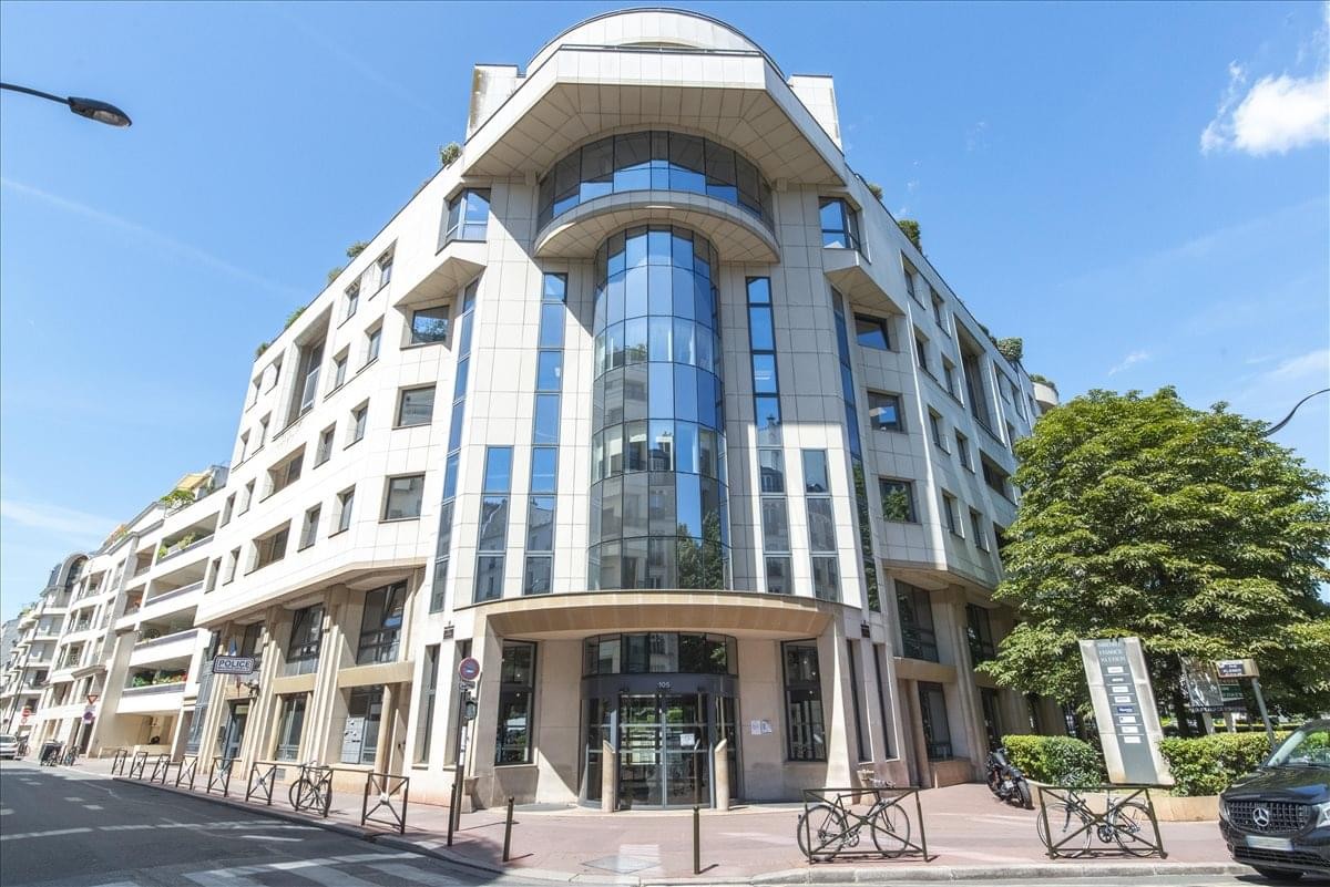 Grand stone exterior with a glass-facade central column at 105 Rue Anatole France.