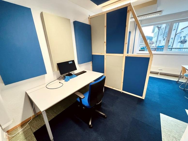 Workspace featuring a wooden partition and blue carpeted flooring.