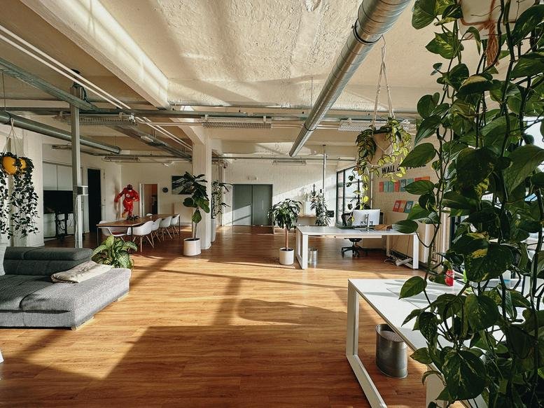 Exterior view of office buildings by the harbor with boats and blue sky.