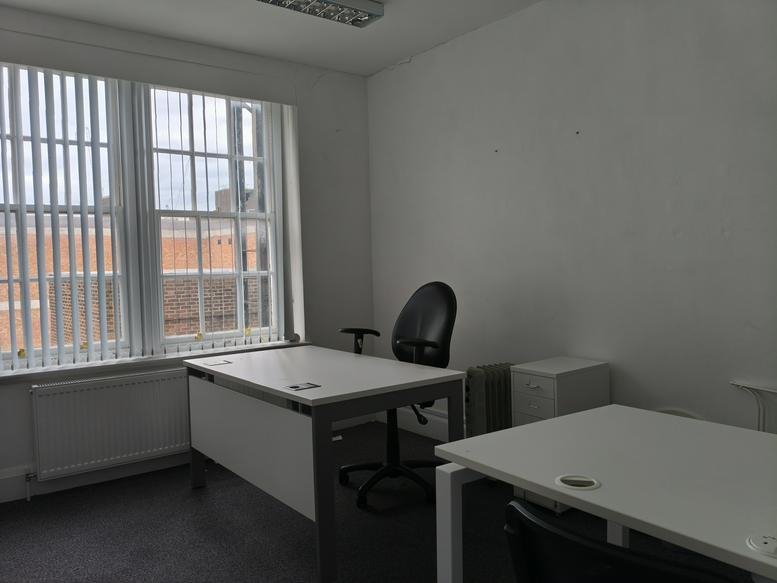 Spacious private office at 74, George Street with large windows and multiple workstations.
