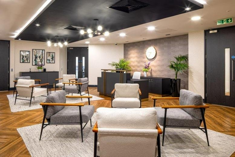 Spacious reception lounge at 75 King William Street with mid-century modern armchairs and wood flooring.