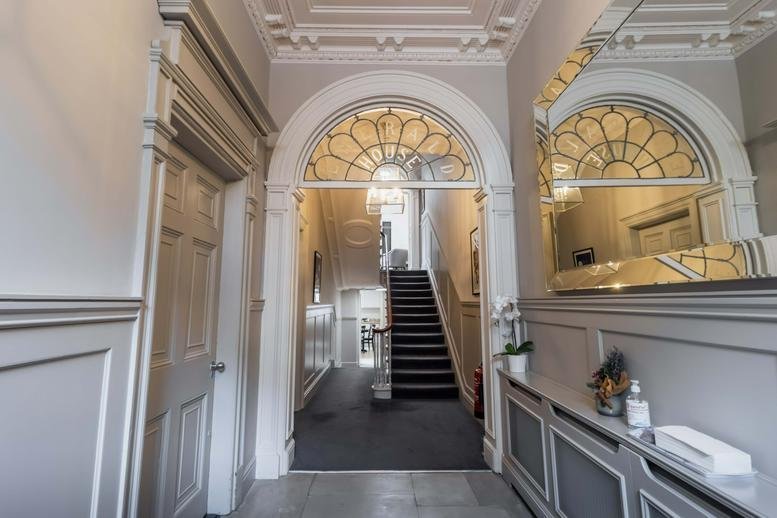 Grand entrance hallway at 8, Herbert Street with period archways and white wood paneling.